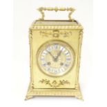 A late 19thC / early 20thC gilt brass clock with enamel numerals, the 8-day movement striking on a