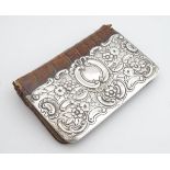 A leather purse with silver embossed detail to front, hallmarked Birmingham 1900, maker Charles