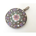 An Italian glass pendant set with millefleur style decoration in a white metal mount. Approx. 1 1/2"