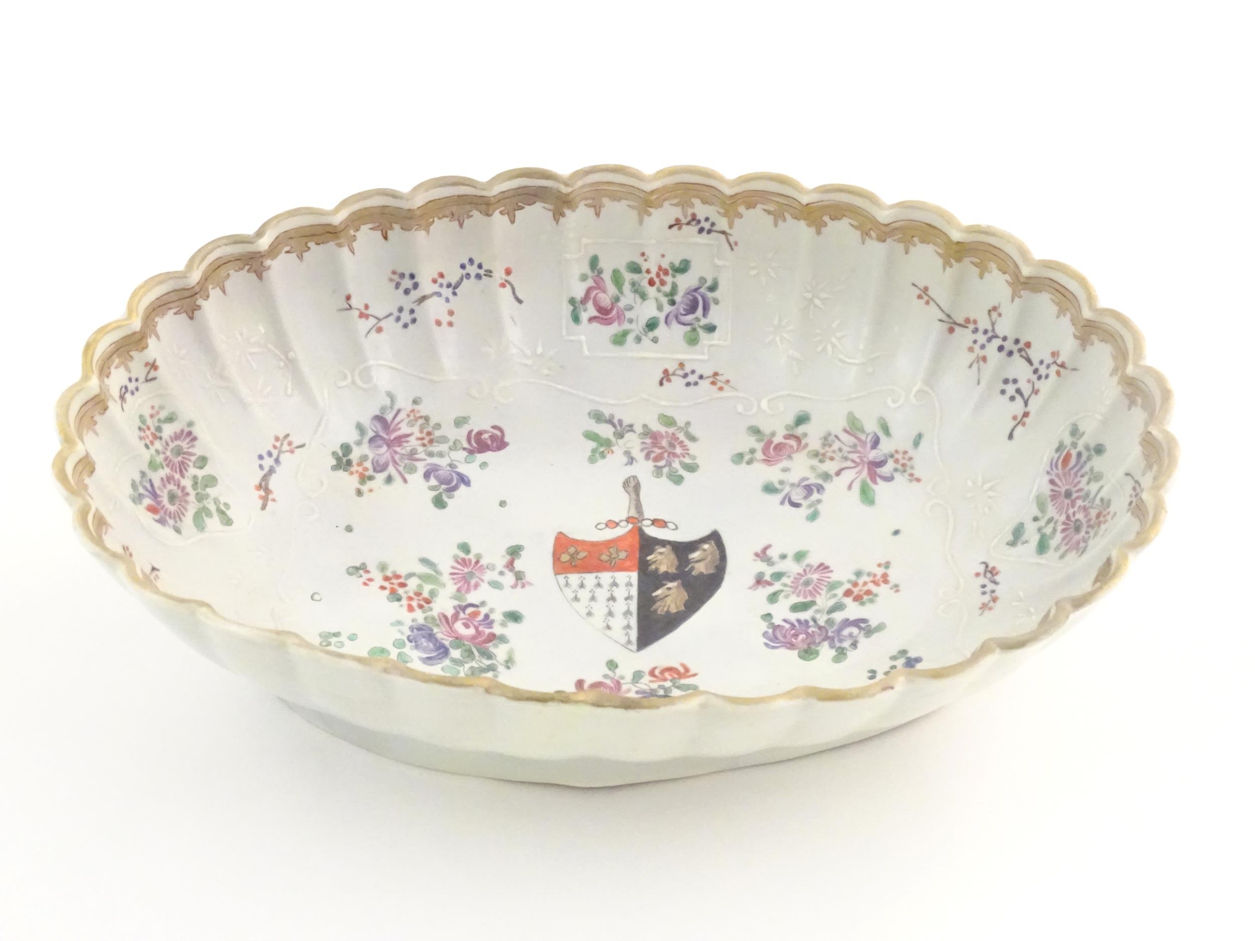 A Chinese export bowl of oval form with scalloped edge, decorated with flowers, foliage and armorial - Image 4 of 7