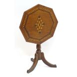 A late 19thC tripod table with an octagonal top having ebonised and satinwood parquetry decoration