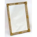 A late 20thC gilt mirror with a decoratively moulded frame and a beaded interior surround. 26 1/2"