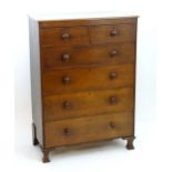 An early 20thC oak chest of drawers with a rectangular top above two short over four long drawers