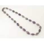 An Amethyst necklace set with white metal mounts . Approx 30" long Please Note - we do not make