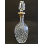 A cut glass decanter with silver collar hallmarked London 1967 maker Harrods Ltd. Approx 12" high