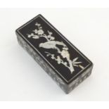 An Oriental papier mache lacquered box with mother of pearl detail depicting a bird perched on a