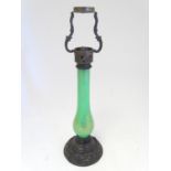 A 19thC Palmers patent table lamp, the patinated brass fitting supported by a green glass column