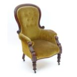 A late 19thC mahogany armchair with a moulded frame and deep buttoned upholstery and standing on