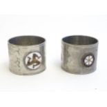 Two pewter napkin rings with hammered decoration, one with applied detail depicting the Isle of