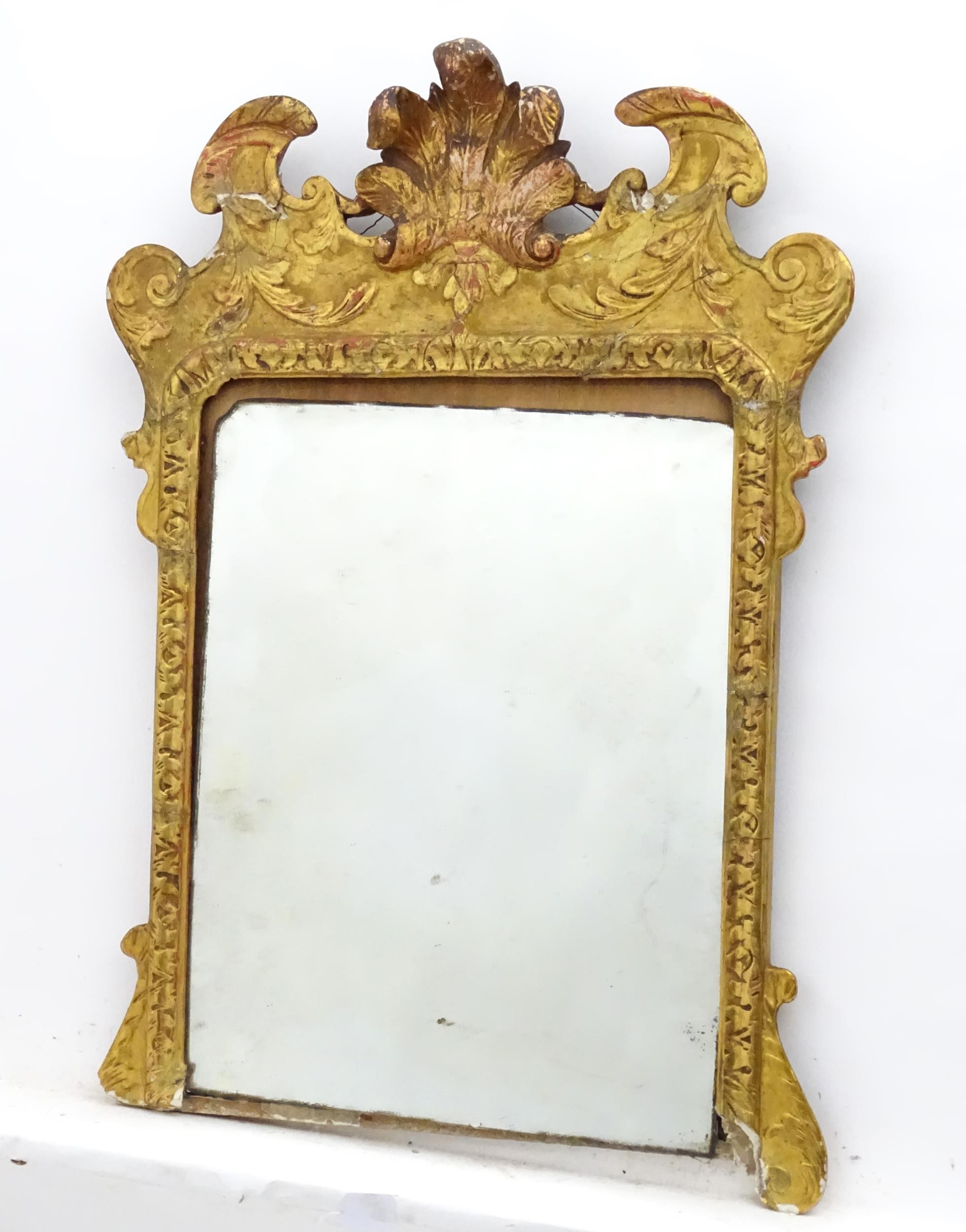 A 19thC gilt mirror with a moulded anthemion to the top and floral decorations to the frame. 23"