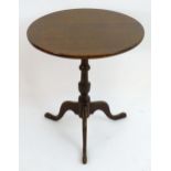 An early 20thC mahogany tripod table with a circular top above a turned tapering column and three