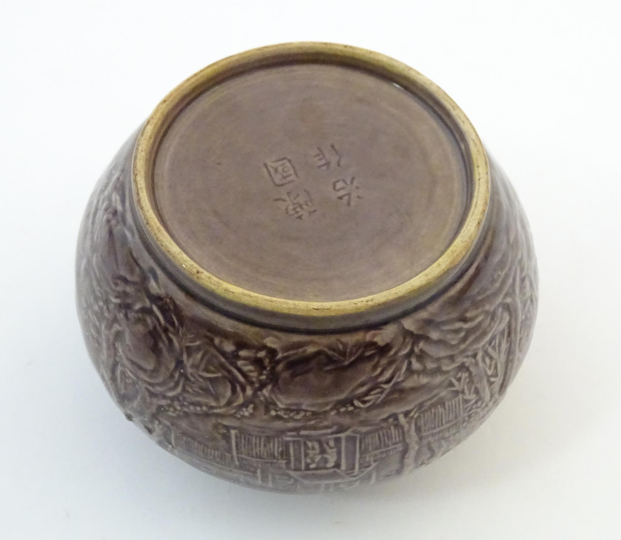 A small Chinese pot of squat form with cast landscape detail. Character marks under. Approx. 2 1/ - Image 3 of 6