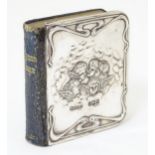 A miniature ' book of Common Prayer, with embossed silver front cover with angel decoration.