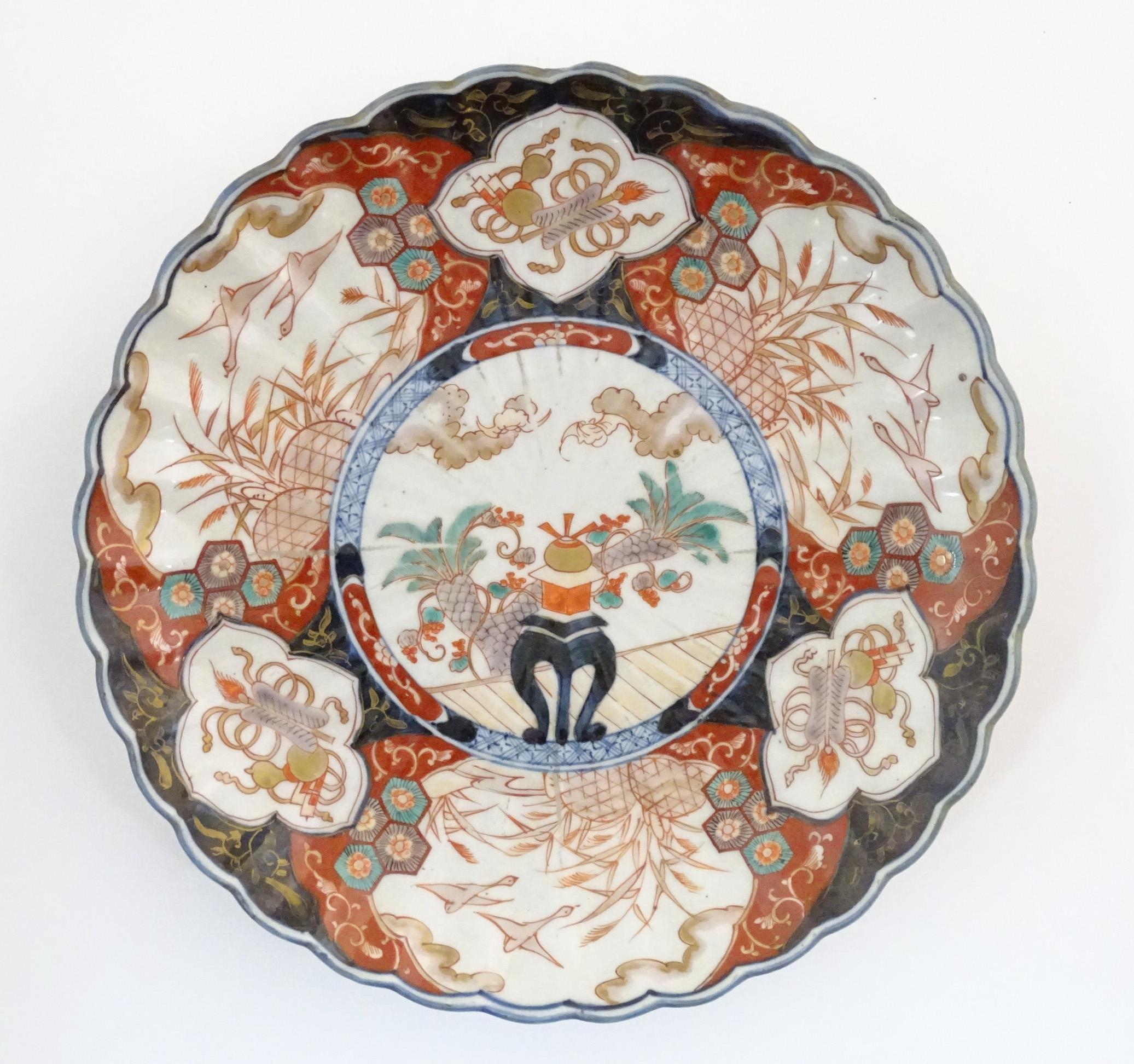 An Oriental charger with scalloped edge in the Imari palette decorated with a stylised censor on
