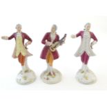 Three Royal Dux figures modelled as an 18th century gentleman, one with a string instrument.