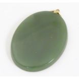 An oval jade coloured pendant. Approx 1 3/4" long Please Note - we do not make reference to the