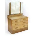 A mid 20thC limed oak dressing chest with a trifold mirror above two short and two long drawers.