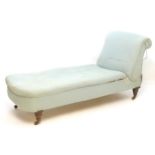 A Victorian chaise longue with a scrolled drop end above turned tapering legs terminating in