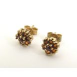 A pair of 9ct gold stud earrings set with red stone clusters. Approx 1/4" diameter Please Note -