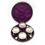 A cased set of four Victorian silver salts of circular form with foliate detail and raised on