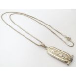 An Egyptian silver pendant and chain, the pendant with hieroglyphic detail. Approx 2" long Please