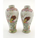 A pair of Chinese famille rose baluster vases decorated with two cockerels / rooster amongst flowers