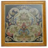 A 19thC needlework tapestry depicting scrolling floral and foliate motifs. In a maple frame. Approx.