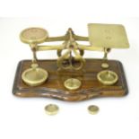 A late 19th / early 20thC brass set of postal scales, standing on a bow front oak base with 4, 2, 1,