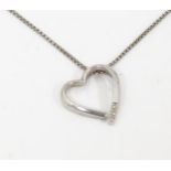 A silver necklace with heart shaped pendant set with diamonds. The whole approx. 18 1/2" long Please