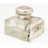 A glass inkwell having unusual silver date panel mount to front and silver lid, hallmarked