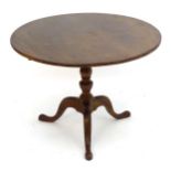 A late 19thC / early 20thC mahogany tripod table with a circular top above a turned column and three