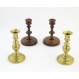 A pair of brass candlesticks with plunger action. Together with a pair of turned oak candlesticks.