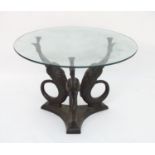 A 20thC bronze occasional table with circular glass top, the triform base with three supports formed
