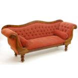 A Victorian mahogany sofa with scrolled ends and deep buttoned upholstery above turned tapering