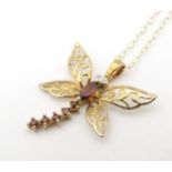 A 9ct gold necklace the pendant formed as a dragon fly set with diamonds and red stones, on a a