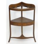 An early 19thC mahogany corner washstand with a circular insert above a lower tier and a small