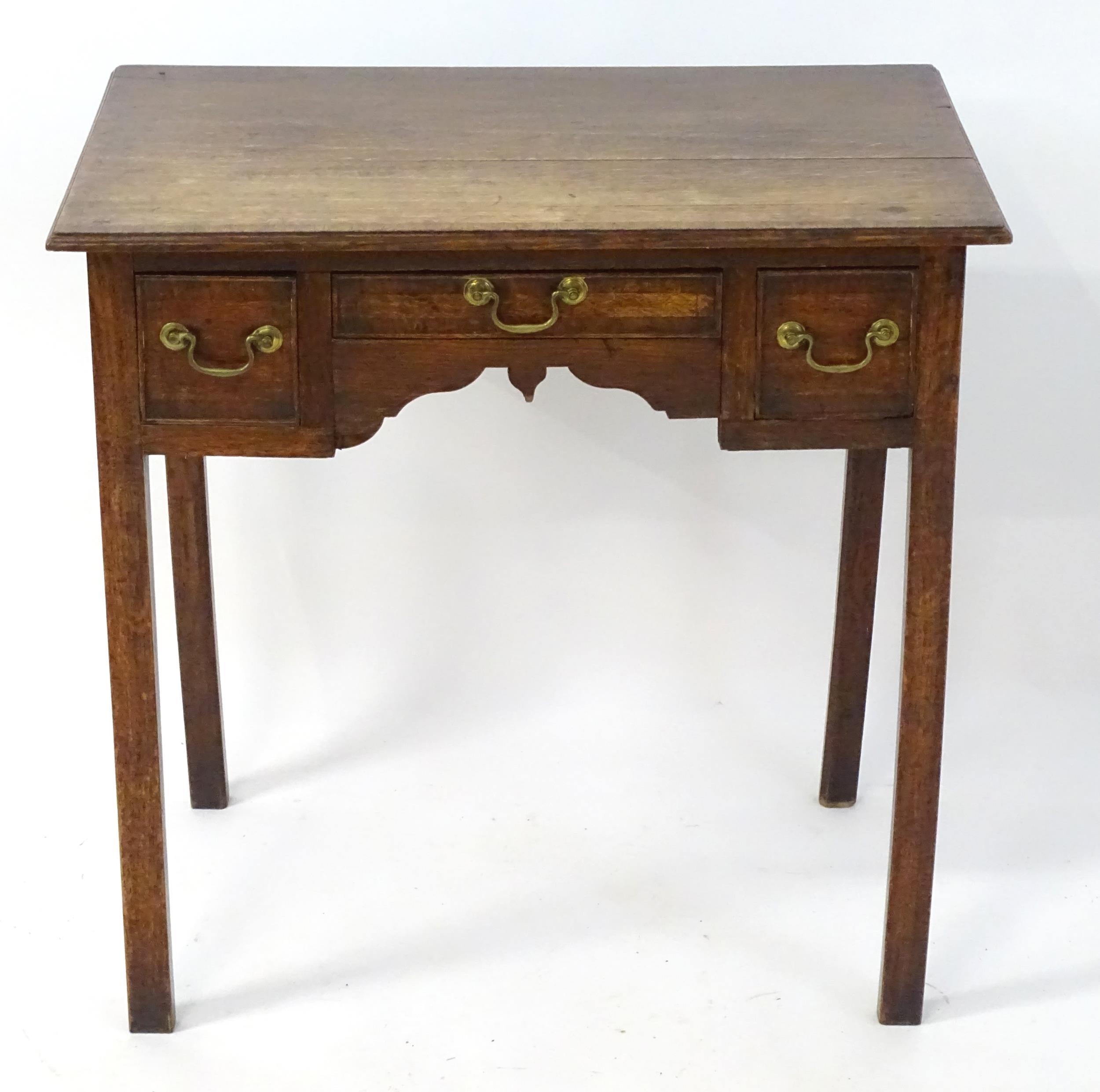 An early 19thC oak lowboy with crossbanded decoration, a rectangular moulded top above three short