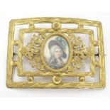 A late 19th / early 20thC gilt painted buckle formed brooch with central hand painted portrait
