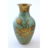 A 20thC brass vase of baluster form with floral and foliate decoration and enamel detail to body.