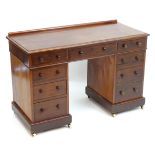 A Victorian mahogany double pedestal desk with two banks of four drawers and a central drawer with
