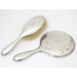 A silver backed hand mirror and hair brush hallmarked Birmingham 1923 maker Daniel Manufacturing