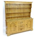 A mid 20thC pine dresser with a moulded cornice above three graduated shelves on the plate rack, the