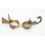 Two early 20thC gilt metal skirt lifters formed as clasped hands. Largest 2" long (2) Please