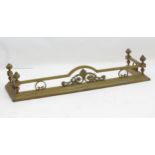 A Victorian brass fire fender with cast scrolling decoration. Approx. 10" high x 53" wide x 15" deep