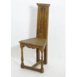 An early 20thC Arts and Crafts Shakespeare chair of oak construction , with a narrow panelled back