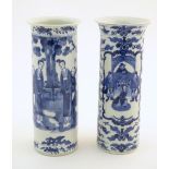 Two Oriental blue and white vases of cylindrical form, one depicting figures in a garden scene