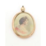 A pendant of oval form with photographic portrait miniature to centre within a 9ct gold surround.