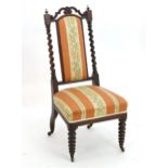 A late 19thC rosewood bobbin turned nursing chair with a shaped and pierced cresting rail. 18"