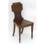 A mid 19thC mahogany hall chair with a shaped backrest with reeded and moulded decoration above