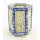 An Oriental hexagonal pot pourri holder with blue and white floral detail and reticulated panels.